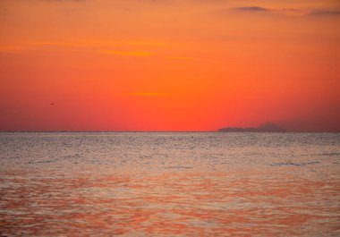 Sabahın erken saatlerinde, denizin üzerinde dramatik altın gün doğumu