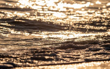 Dalgalar deniz kıyısına vuruyor Makro güneş doğuşunu kapatıyor