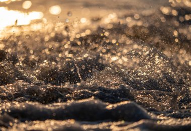 Dalgalar deniz kıyısına vuruyor Makro güneş doğuşunu kapatıyor