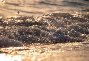 Dalgalar deniz kıyısına vuruyor Makro güneş doğuşunu kapatıyor