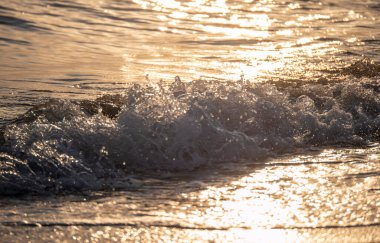Dalgalar deniz kıyısına vuruyor Makro güneş doğuşunu kapatıyor