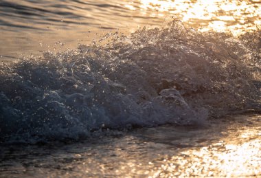 Dalgalar deniz kıyısına vuruyor Makro güneş doğuşunu kapatıyor