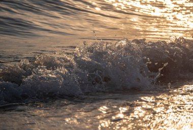 Dalgalar deniz kıyısına vuruyor Makro güneş doğuşunu kapatıyor