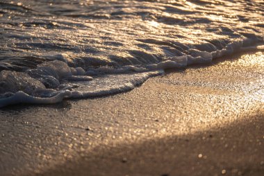 Dalgalar deniz kıyısına vuruyor Makro güneş doğuşunu kapatıyor