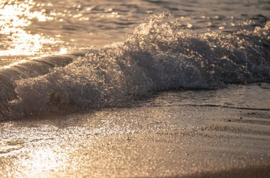 Dalgalar deniz kıyısına vuruyor Makro güneş doğuşunu kapatıyor