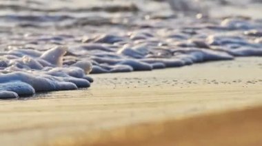 Gün batımında plaj dalgası sıçrayan makro