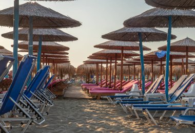 Şemsiyeli plaj ve turistsiz güneşlik.