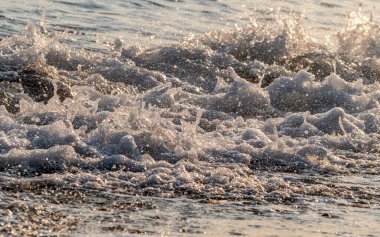 Dalgalar deniz kıyısı makrosu sıçratıyor. Yaklaş.