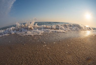 Dalgalar deniz kıyısındaki makroyu vuruyor.