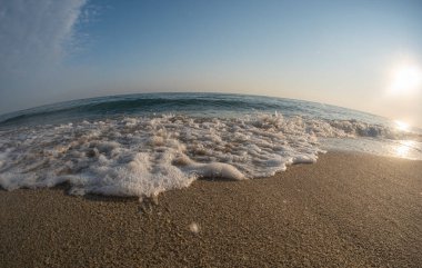 Dalgalar deniz kıyısındaki makroyu vuruyor.