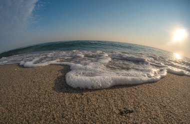 Dalgalar deniz kıyısındaki makroyu vuruyor.