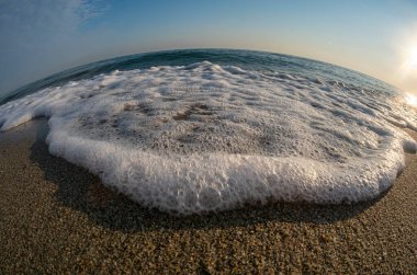 Dalgalar deniz kıyısındaki makroyu vuruyor.