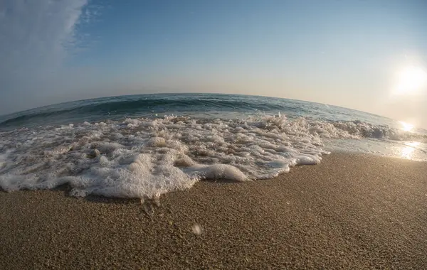 Dalgalar deniz kıyısındaki makroyu vuruyor.
