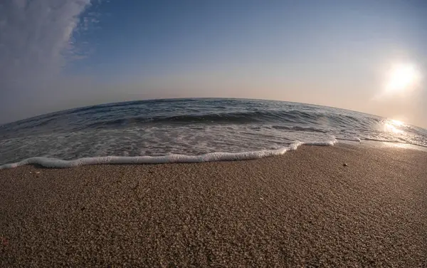 Dalgalar deniz kıyısındaki makroyu vuruyor.