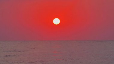 Büyük güneş denizin üzerinde, kırmızı gökyüzü yavaş çekim 4k