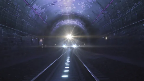 Karanlık bir demiryolu tünelinde kameraya doğru gelen parlak tren ışıkları