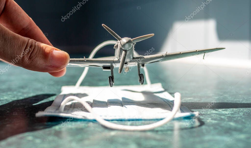 A small toy airplane placed on a face mask