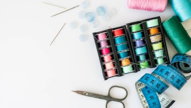 Dikiş aksesuarlarının bir tarafı tıkalı olmayan çeşitli iplikler, düğmeler, iğneler, makaslar.