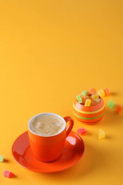 turuncu fincan kahve metin için yer ile sarı bir arka plan üzerinde şekerlenmiş meyve ile