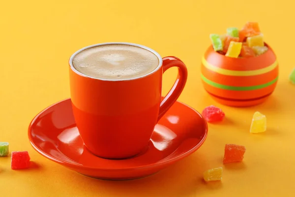 橙色杯咖啡与蜜饯水果在黄色背景特写 — 图库照片
