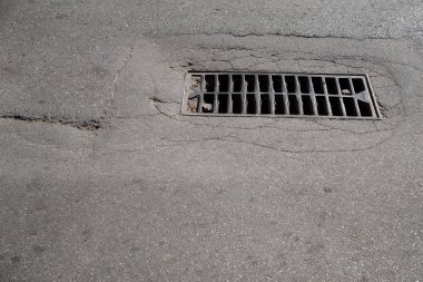 Yağmur drenaj rendeleyin gri düşen asfalt üzerinde