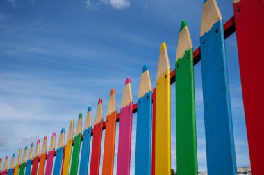 metin için arka plan mavi gökyüzü ile yer üzerinde kalem şeklinde dekoratif çit