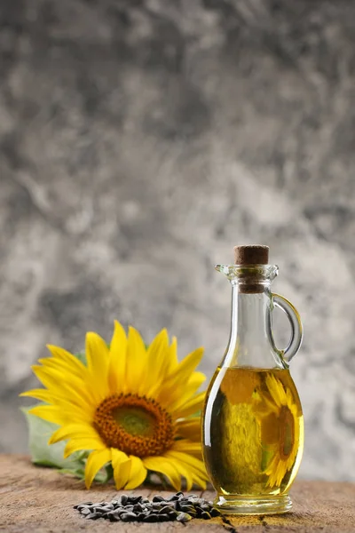 Zonnebloemolie, zaad en zonnebloem op de achtergrond van houten bo — Stockfoto