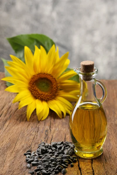 Slunečnicový olej, semeno a slunečnice na pozadí dřevěná bo — Stock fotografie