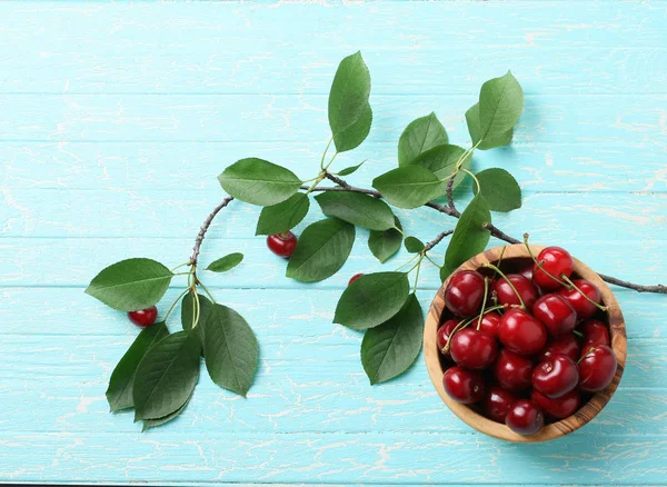 Cerezas maduras en un tazón de madera sobre el fondo de jabalí pintado — Foto de Stock