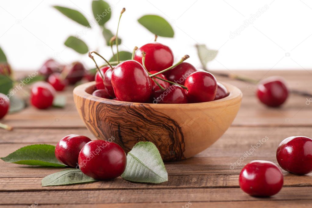 ripe cherries in a wooden bowl on the background