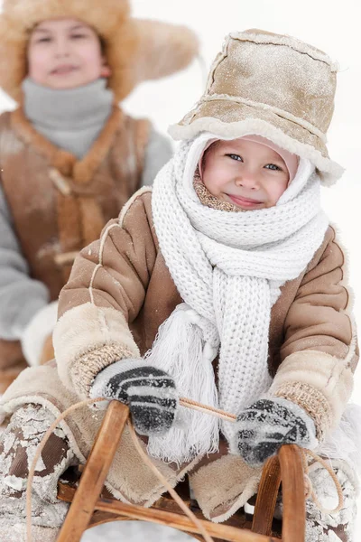 男孩和女孩雪橇与果皮在一个冬天的一天 — 图库照片