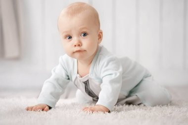 Odamdaki halıda sürünen bir bebeğin portresi.
