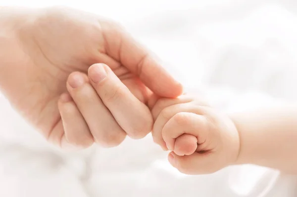 Main Enfant Dans Une Main Mère Sur Oreiller — Photo