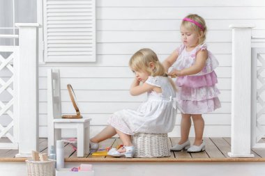 İki küçük kız güzellik salonu bulunan evde verandada oynamak