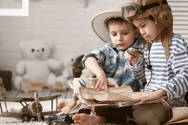 Boys in images traveler and pilot play in his room — Stock Photo, Image