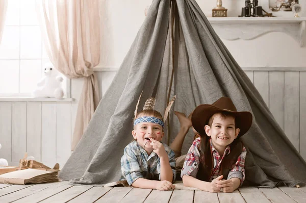 Boys as Indian and cowboy playing in her room — Stock Photo, Image