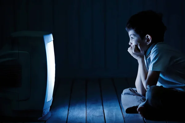Хлопчик дивиться телевізор вночі — стокове фото