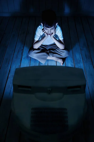 Хлопчик дивиться телевізор вночі — стокове фото