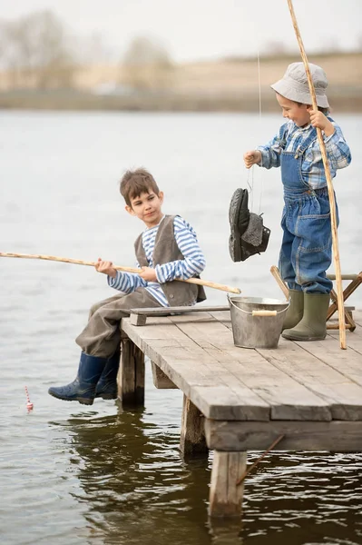 I ragazzi pescano su un ponte sul lago — Foto Stock