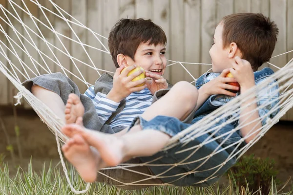 Les enfants mangent des pommes dans un hamac — Photo