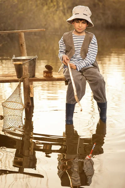 Chłopiec ryby na moście na jeziorze — Zdjęcie stockowe