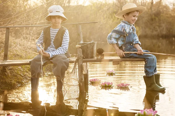 Boys fishes on a bridge on the lake — Stock Photo, Image