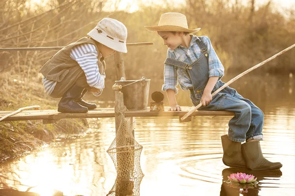 Мальчики рыбачат на мосту на озере — стоковое фото
