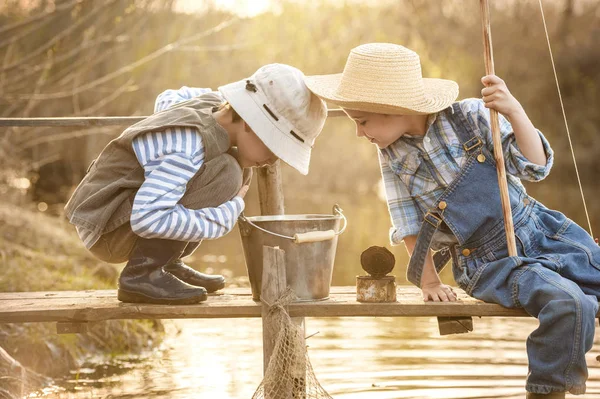男孩们在湖上的桥上钓鱼 — 图库照片