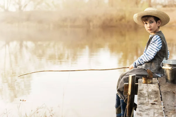 Garçon pêche sur un pont sur le lac — Photo