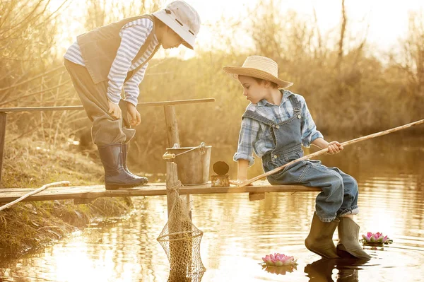 Boys fishes on a bridge on the lake — Stock Photo, Image