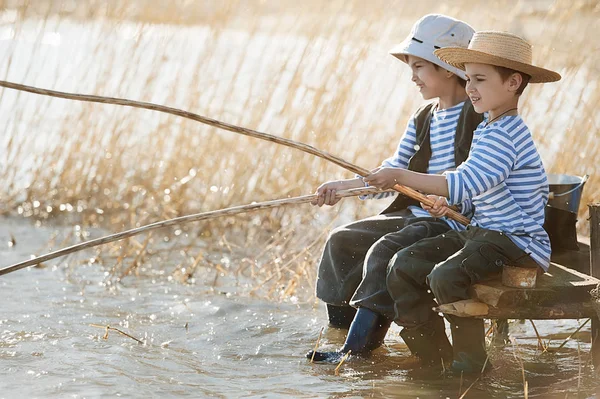 Pojkar fiskar på en bro på sjön — Stockfoto