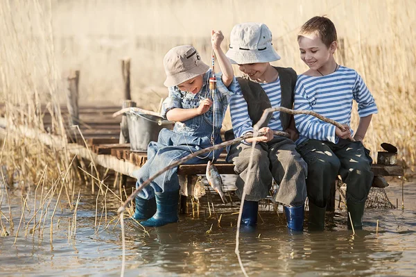 Meninos peixes em uma ponte no lago — Fotografia de Stock