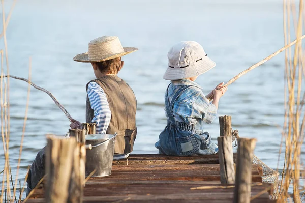 Pojkar fiskar på en bro på sjön — Stockfoto