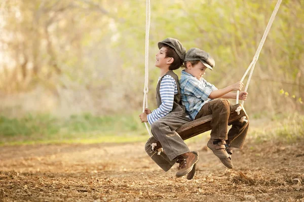 Kinderen op schommels zonnige zomerdag — Stockfoto